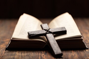 Praying wooden cross and Holy Bible book. Religion concept