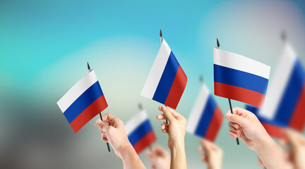 A group of people are holding small flags of Russia in their hands.