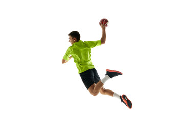 Competitive and concentrated young guy, handball player in motion during game, training against white studio background. Concept of professional sport, tournament, competition