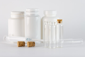 Medical ampoules and syringe on white background, closeup
