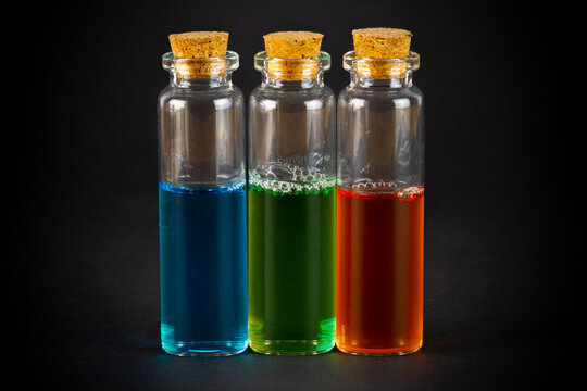 Laboratory test-tubes with colorful liquids on black background.