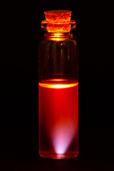 Laboratory test-tubes with colorful liquids on black background.