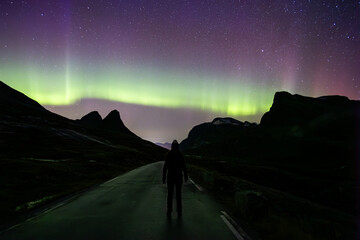 Northern lights and woman in Trollstigen road, South Norway, Europe