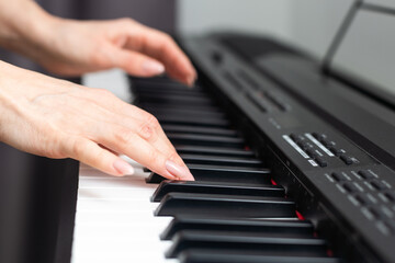 keyboard and hands playing the piano