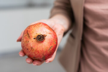 pomegranate fruit fresh in hand on white background isolation