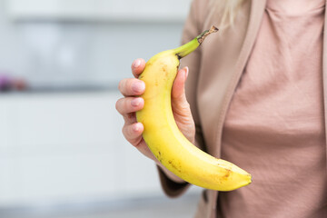 A woman holding a banana in one hand