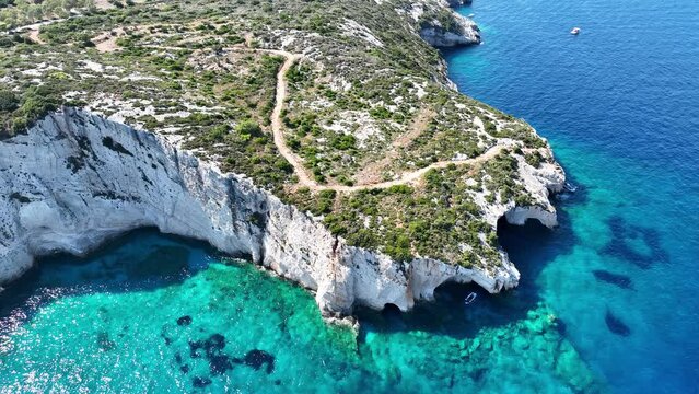 Blue Caves located between Aghios Nikolas and Cape Skinnari. Blue caves in zakynthos, Greece. Potamitis Dive Spot, Zakynthos, greece. Skinari View Point. Aerial drone view Turquoise ionian sea.