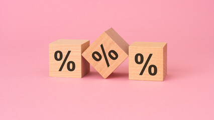 the percent sign on wooden cubes, pink background