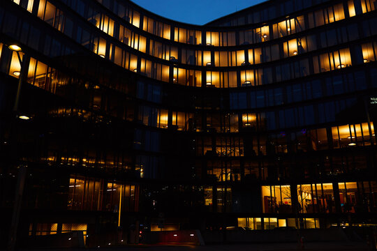 Office Building Exterior With Glowing Lights In Windows At Night City. Vienna City Downtown District With Skyscraper Facades. Night City Panorama. Working Late At Corporation