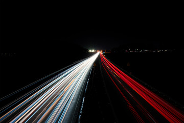 Light trails on the highway at night. Rush hour on motorway with glowing cars headlamps, long...