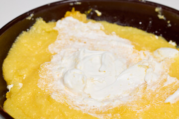 (Mamaliga) with cheese, eggs, and cream in a plate.
