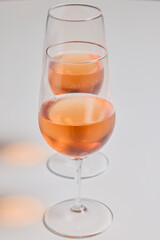 two glasses of rose wine on a table.