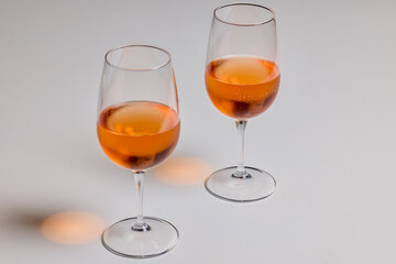 two glasses of rose wine on a table.