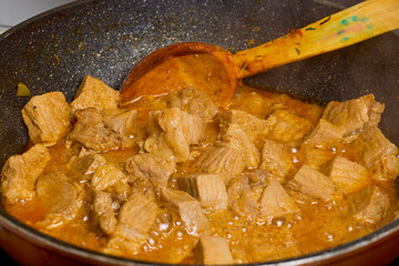 Pork cut into pieces in a wok for cooking