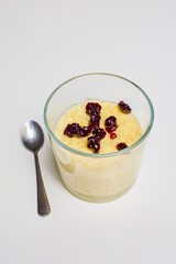 a glass bowl with dessert, tapioca pudding with vanilla and blueberry jam.