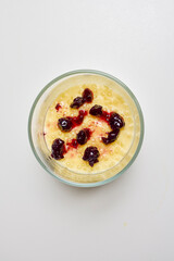 a glass bowl with dessert, tapioca pudding with vanilla and blueberry jam.
