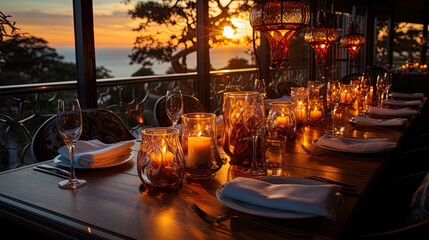 A luxurious table in a restaurant with a view of the sunset, where candles and candelabra create a