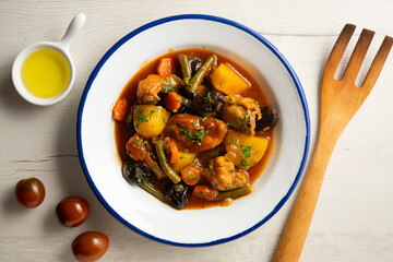 Stewed rabbit with potatoes, green beans, carrots and tomato.