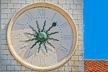 Fototapeta na wymiar antique clock with a copper sculpted sun in the middle against the sky