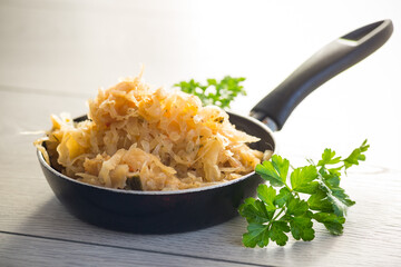 cabbage stewed with spices and carrots in a frying pan ,