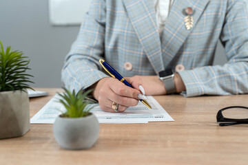 Business woman filling  individual income tax return form, tax documents in office