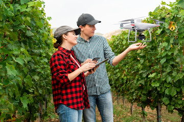 Couple of farmers control drone with a tablet. Smart farming and agriculture 4.0.