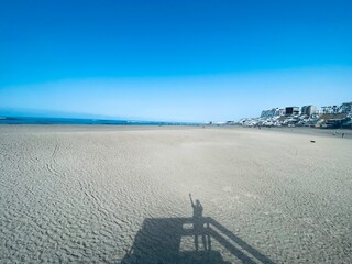 Playa peruana  solitaria con mar de fondo, sombra de persona.
