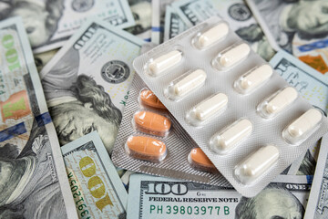 US paper dollars bills with different color medicine pills