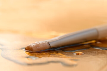 Cosmetic brush lying in serum, emulsion to moisturize the face.