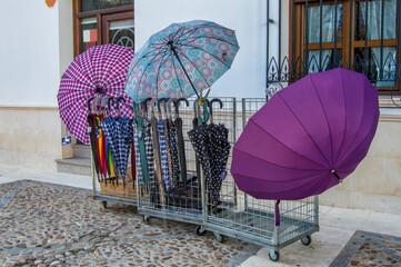 several colored umbrellas on a stall in an open-air market