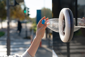 Woman uses a self service machine to receive used plastic bottles and cans on a city street..
