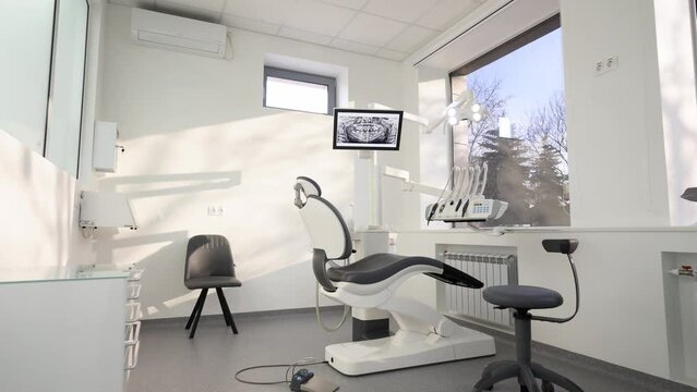 Dentistry office with professional modern equipment. Empty minimalistic stomatology office with dental unit, chair and professional equipment. Dental chair in the medical clinic. Workplace of dentist.