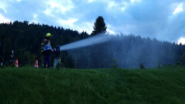 fireman, rescuer teaches children to put out fires. Europe, Poland