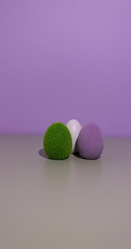 A green cute bunny, transforming into an Easter egg, soft pastel purple and grey background with copy space, on a soft purple and grey background with copy space.