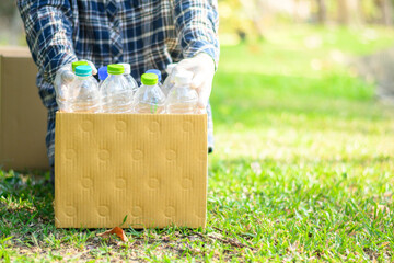 Volunteers collect plastic bottles in cardboard boxes in the park. Disposal, recycling and waste...