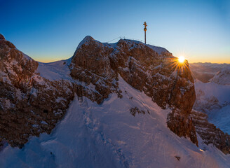 Sunrise morning glow at the Zugspitze with the summit cross at the background
