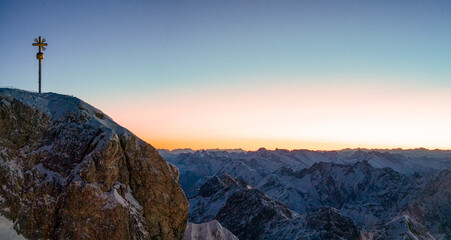 Sunrise morning glow at the Zugspitze with the summit cross at the background