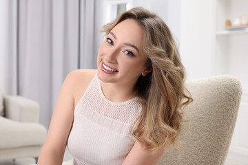 Naklejka premium Portrait of smiling woman with curly hair at home