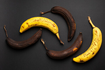 Rotten bananas on a black background from above. Bananas that are beginning to spoil and bananas...