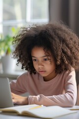 Fototapeta na wymiar African American little girl with curly hair sitting at the table, writing and doing homework
