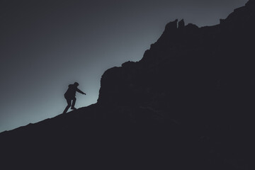 Silhouette eines Wanderers am Berghang bei Dämmerung