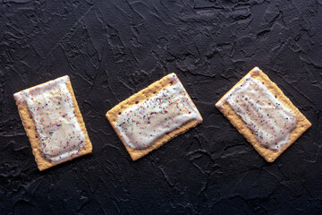 Pop tarts. Poptart toaster pastry with icing on a black background, overhead