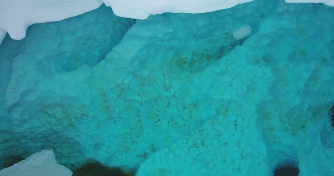 Crystal blue underwater Arctic iceberg melted ice. Snow cover glaciers melting in cold ocean water. Environment issue of global warming. Climate change concept ecology background. Aerial top down view