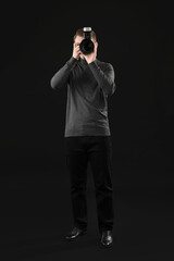 Professional photographer taking picture on black background