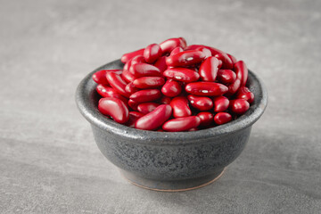Bowl with raw red beans on the table. Front view from low angle.