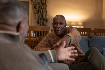 Men talking in living room © Cultura Creative