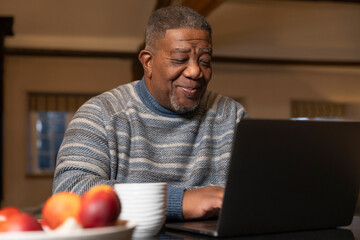 Senior man using laptop at home  © Cultura Creative
