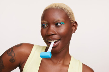 Woman with short white hair, holding party horn blower in mouth