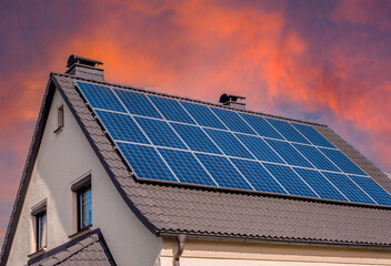 solar panels on roof with sunset