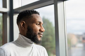 Young businessman looking through office window